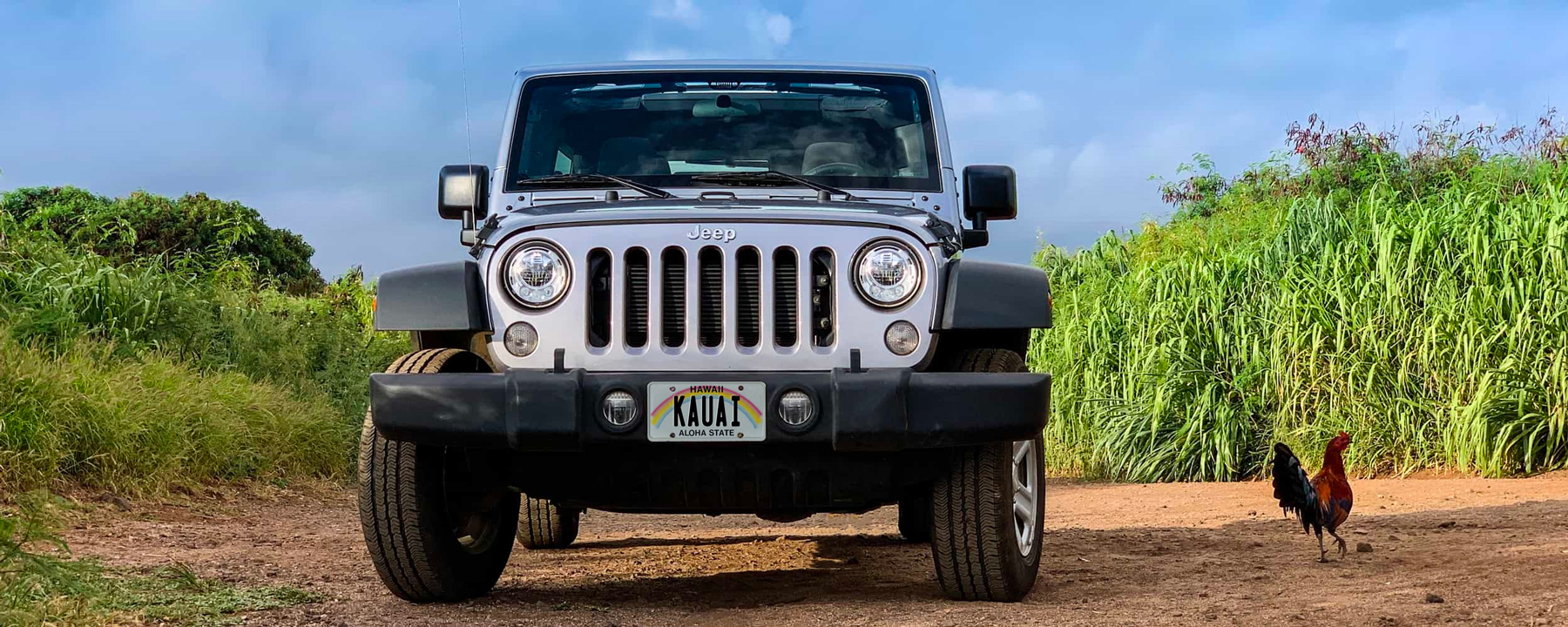 Jeep parked in front of the entrance sign to the Kauai Airport in Lihue (LIH)